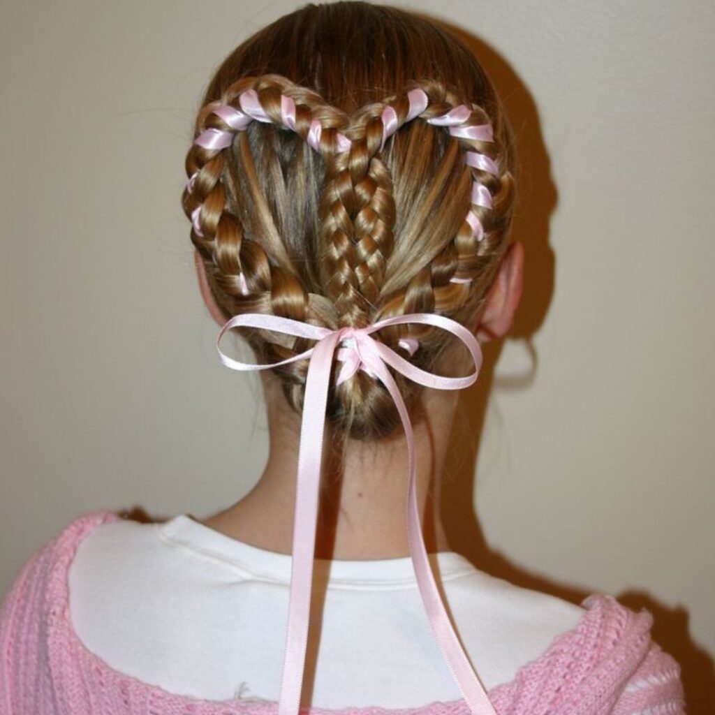 Una niña con un lazo rosa en el pelo, luciendo una trenza de corazón con cinta en el año 2024.